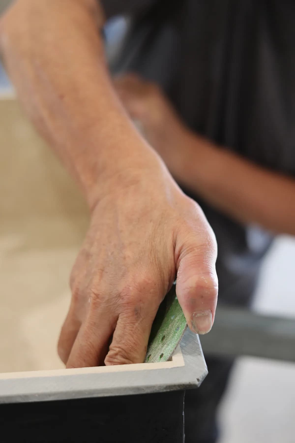 Working the inner edge by hand with an abrasive tool.