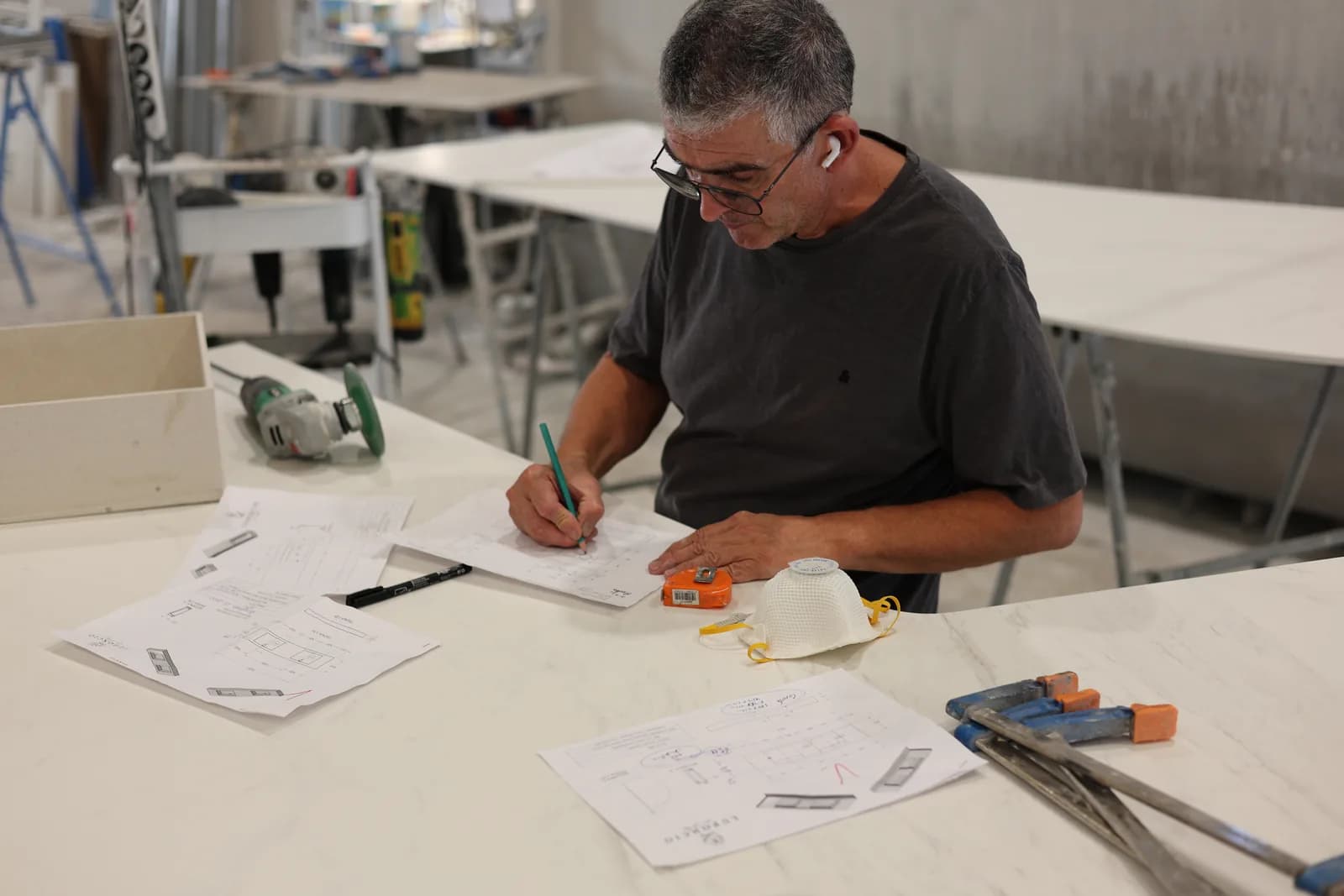 Reviewing and annotating drawings beside the piece and tools.