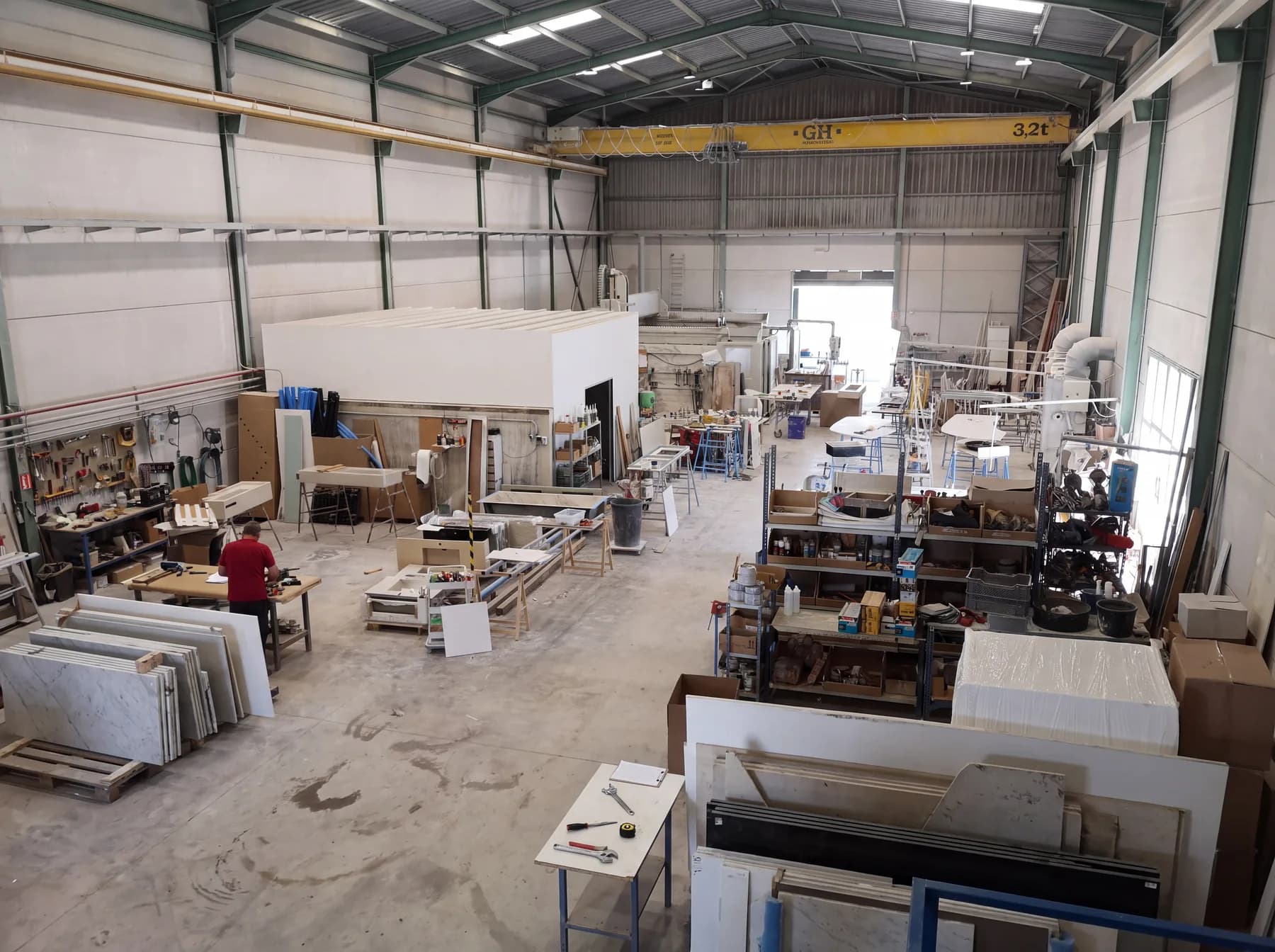 An overview of the workshop, with benches, materials and work areas.